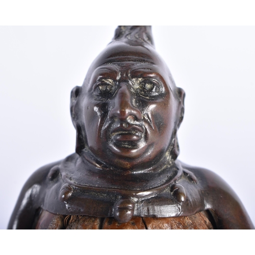 76 - A RARE 19TH CENTURY EUROPEAN BRONZE AND NUT FIGURE OF A TRIBAL WARRIOR modelled wearing feathers and... 