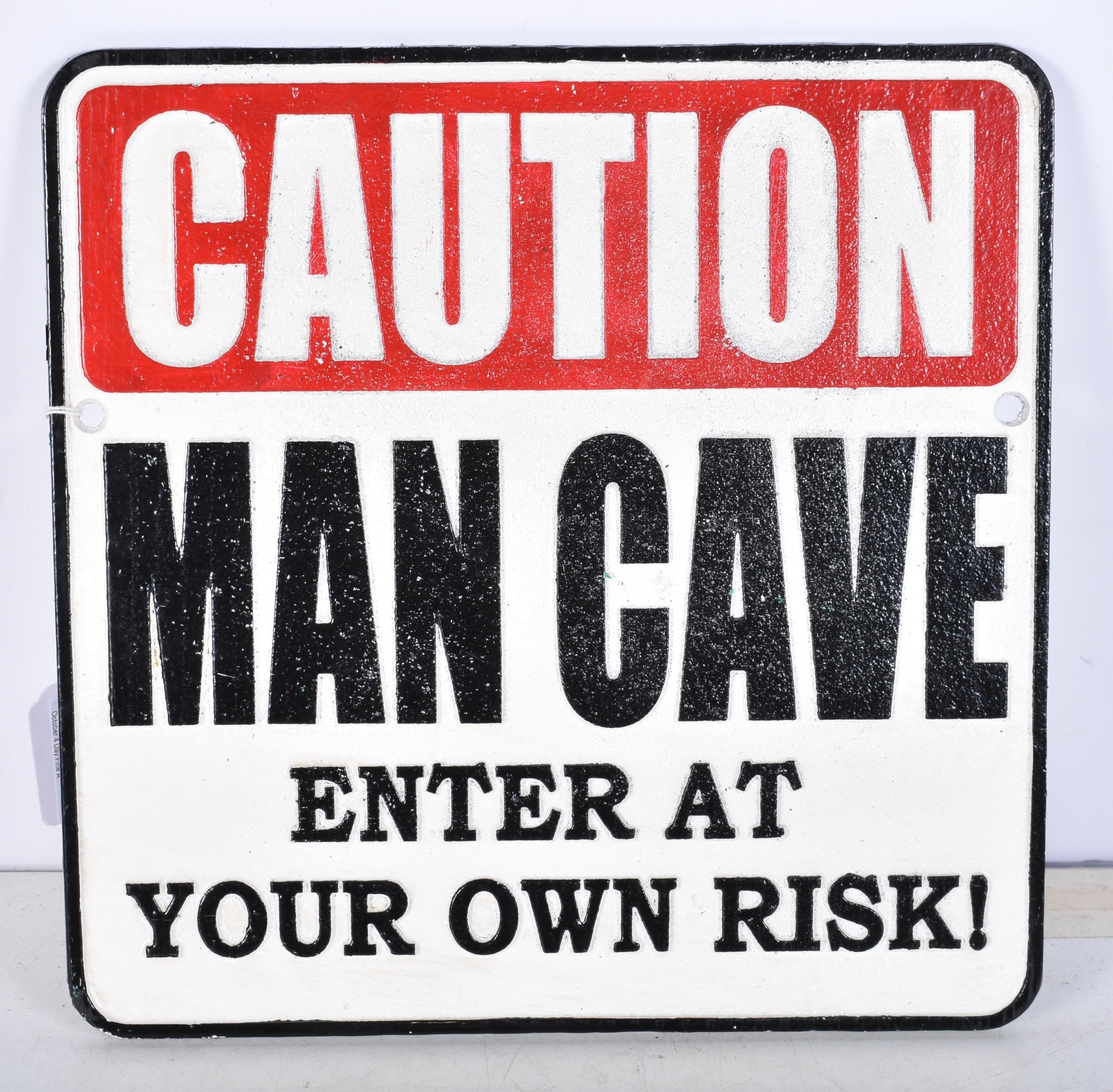 A cast iron Man Cave plaque. 25 cm x 24.5 cm.
