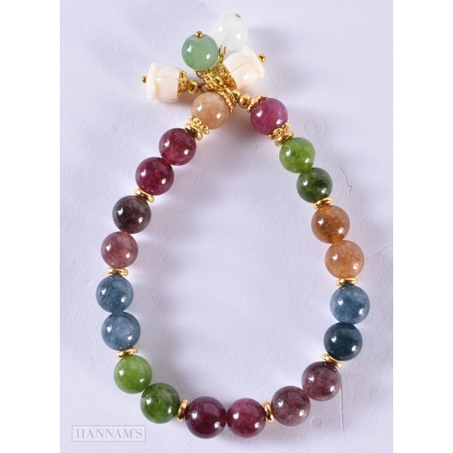 120 - A CHINESE CARVED TOURMALINE AND JADE YELLOW METAL BRACELET. 20.8 grams. 5 cm internal diameter.