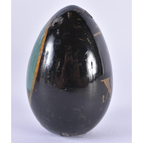 146 - A 19TH CENTURY RUSSIAN BLACK LACQUER EGG painted with a religious building. 7.5 cm x 4.5 cm.