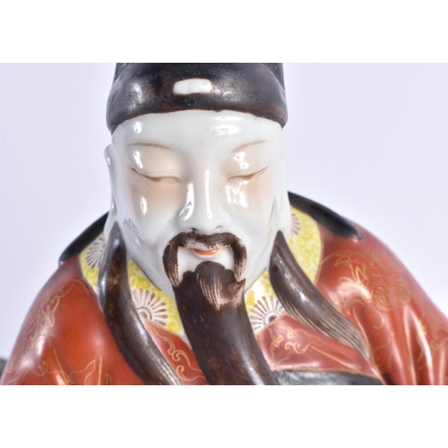 233 - A 19TH CENTURY CHINESE CORAL GROUND PORCELAIN FIGURE OF A SCHOLAR Qing, modelled resting upon an ope... 