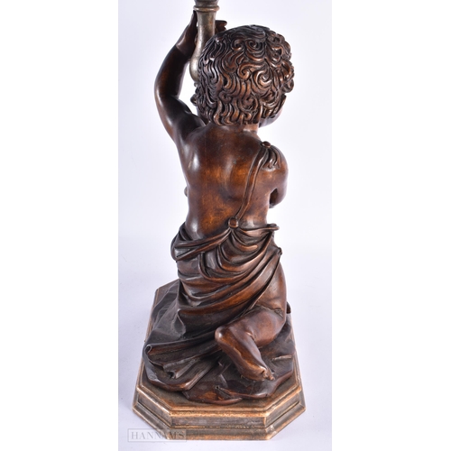 33 - A LARGE 18TH/19TH CENTURY ITALIAN CARVED WOOD LAMP modelled holding aloft a candlestick. 52 cm x 24 ... 