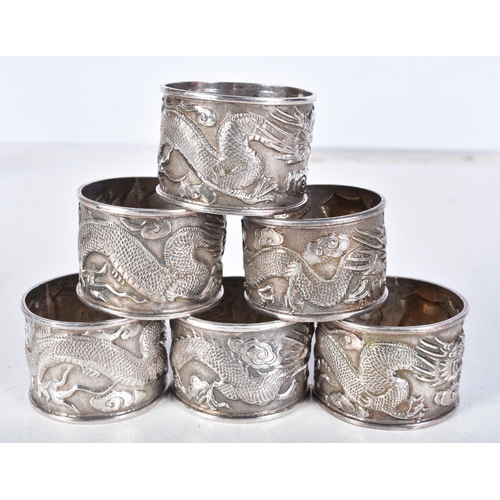 628 - Six Chinese Silver Napkin Rings with Embossed Dragon Decoration.  Chinese Marks.  4.2cm x 3.2cm, tot... 