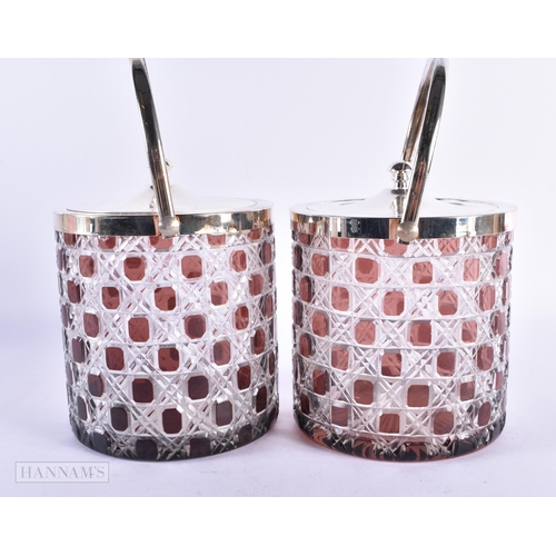 7 - A PAIR OF SILVER PLATED RUBY AND CLEAR GLASS BISCUIT BARRELS AND COVERS. 20 cm high inc handle.