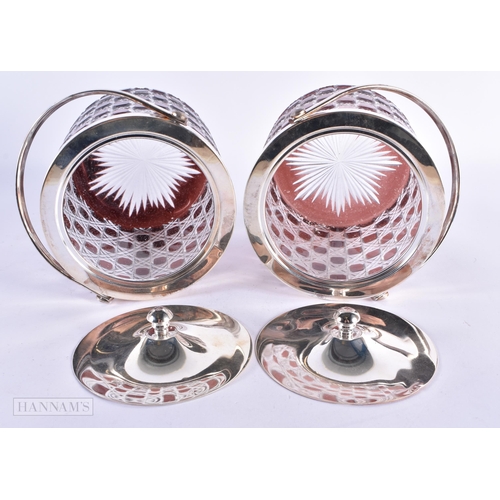 7 - A PAIR OF SILVER PLATED RUBY AND CLEAR GLASS BISCUIT BARRELS AND COVERS. 20 cm high inc handle.