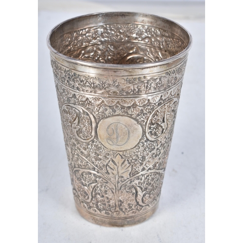 725 - A Middle Eastern Silver Drinking Cup with Embossed Foliate Decoration.  9.4cm x 6.7cm, weight 61.9g