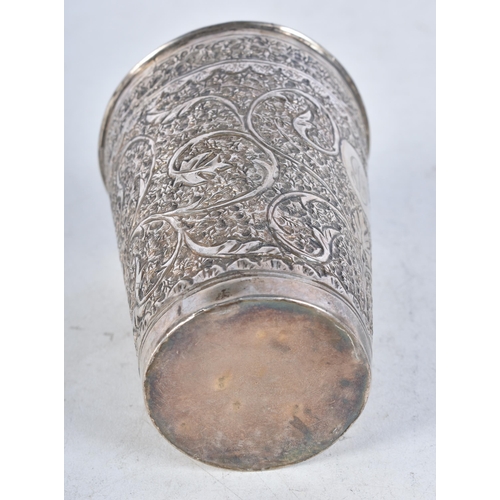 725 - A Middle Eastern Silver Drinking Cup with Embossed Foliate Decoration.  9.4cm x 6.7cm, weight 61.9g