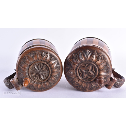 86 - A CHARMING PAIR OF ANTIQUE TREEN TANKARDS carved with leaves. 14 cm x 7 cm.