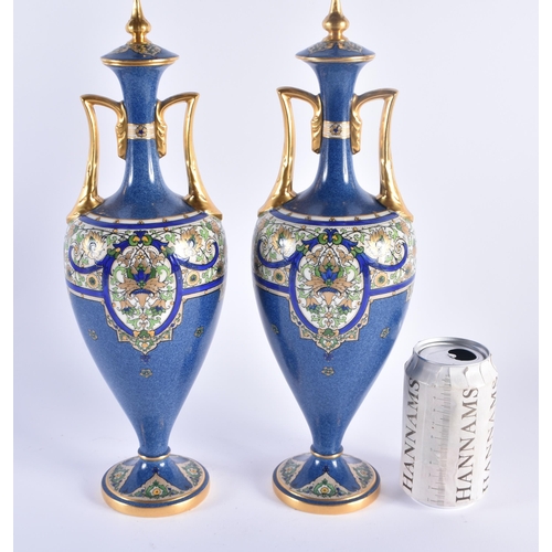 1153 - A PAIR OF ROYAL WORCESTER TWIN HANDLED PORCELAIN VASES AND COVERS painted in relief with Islamic sty... 