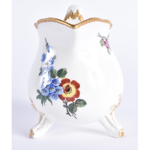 1156 - Late 18th century Sevres three footed cream jug painted with flowers, no mark. 10 cm high.