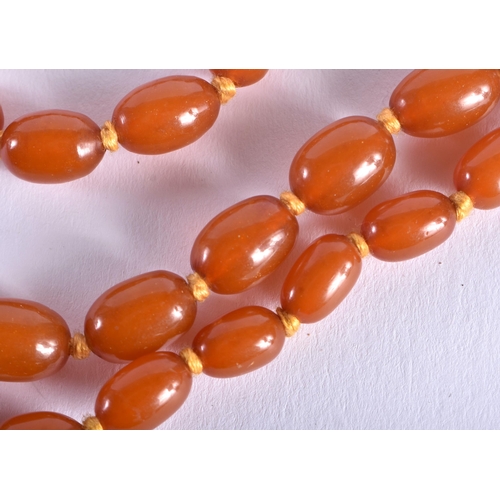 1315 - AN ART DECO SILVER MOUNTED AMBER TYPE NECKLACE. 31 grams. Each stand 46 cm long, largest bead 1.75 c... 