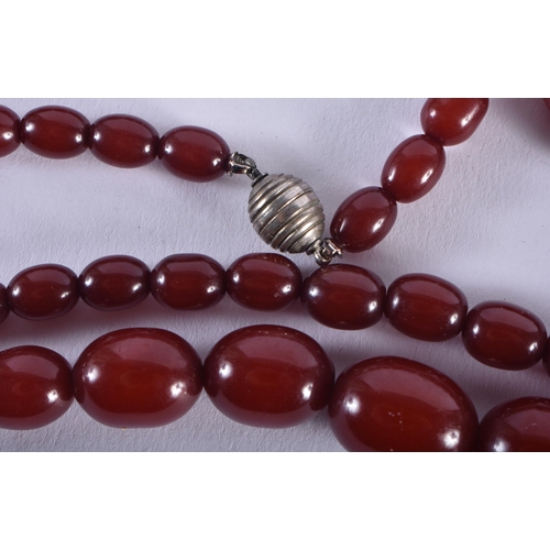 1322 - A CHERRY AMBER TYPE NECKLACE. 52 grams. 70 cm long, largest bead 2.5 cm x 1.75 cm.