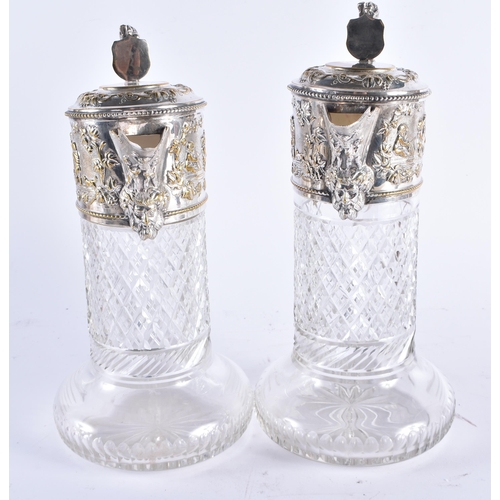 1387 - A PAIR OF ANTIQUE SILVER PLATED CUT GLASS CLARET JUGS formed with heraldic lions, decorated with fig... 