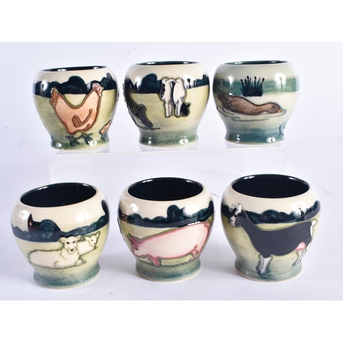 1405 - AN UNUSUAL SET OF MOORCROFT EGG CUPS. Each cup 5.5 cm high. (6)