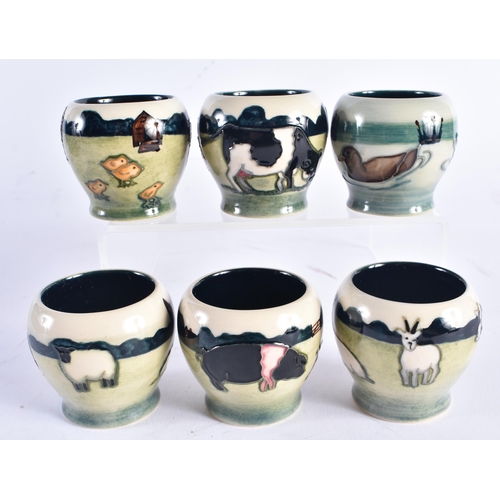 1405 - AN UNUSUAL SET OF MOORCROFT EGG CUPS. Each cup 5.5 cm high. (6)