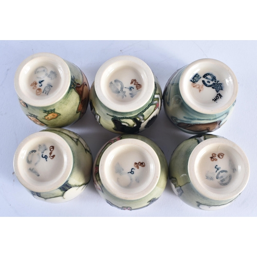 1405 - AN UNUSUAL SET OF MOORCROFT EGG CUPS. Each cup 5.5 cm high. (6)