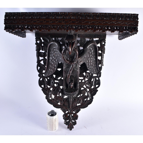 1438 - AN UNUSUAL 19TH CENTURY ANGLO INDIAN CARVED HARDWOOD HANGING PEDESTAL STAND formed with a bird with ... 