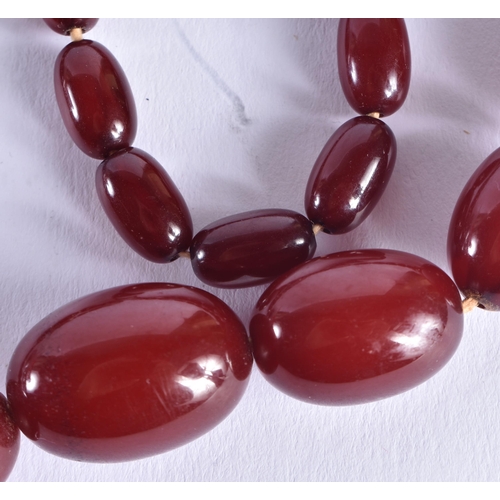 1507 - A CHERRY AMBER TYPE NECKLACE. 47.1 grams. 72 cm long, largest bead 2 cm x 1.5 cm.