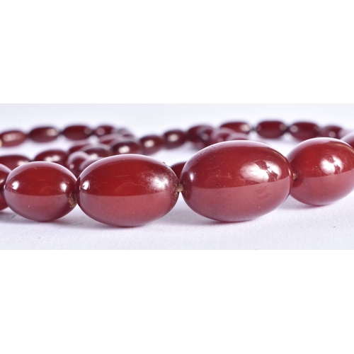 1507 - A CHERRY AMBER TYPE NECKLACE. 47.1 grams. 72 cm long, largest bead 2 cm x 1.5 cm.