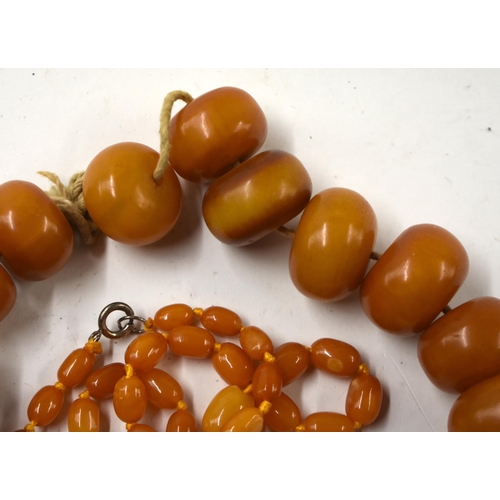 863 - TWO AMBER NECKLACES together with a cheroot holder & a boulder. (4)