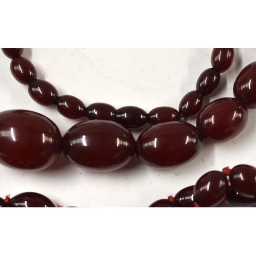 872 - TWO ART DECO CHERRY AMBER TYPE BAKELITE NECKLACES. Longest 84 cm long, largest bead 3 cm x 2 cm. (2)