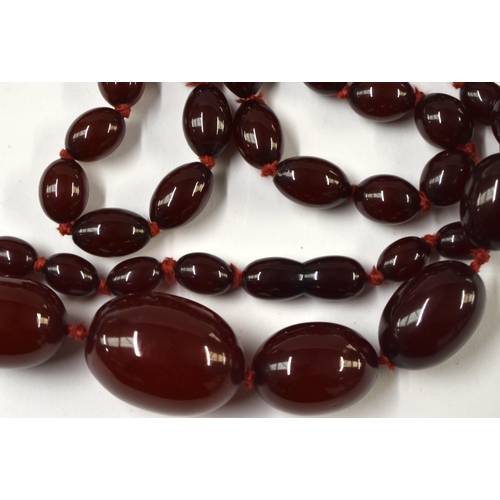 872 - TWO ART DECO CHERRY AMBER TYPE BAKELITE NECKLACES. Longest 84 cm long, largest bead 3 cm x 2 cm. (2)