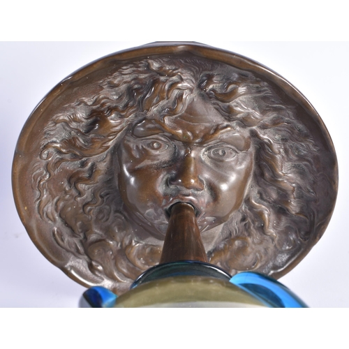 990 - AN UNUSUAL 19TH CENTURY GRAND TOUR BRONZE AND GLASS VASE formed as a mask head blowing aloft a glass... 