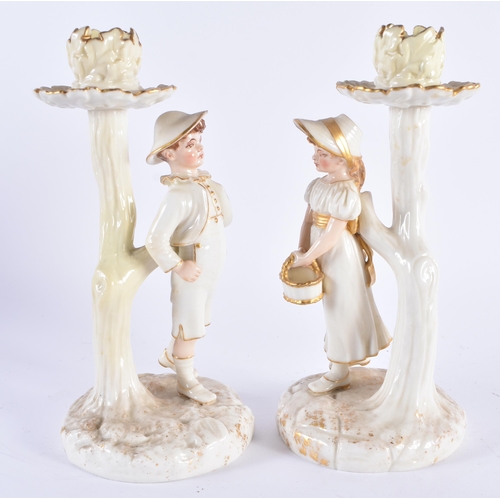 131 - A PAIR OF ROYAL WORCESTER PORCELAIN CANDLESTICKS formed with figures. 19 cm high.