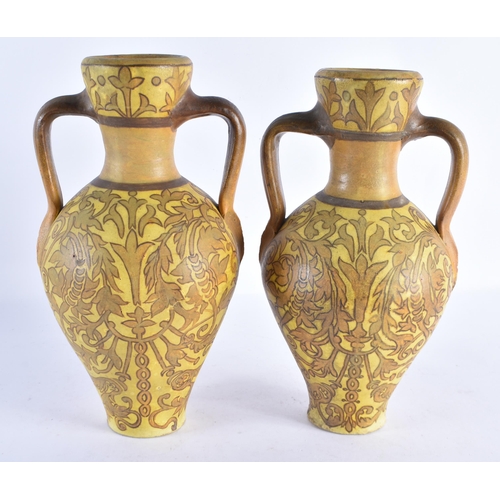 231 - A PAIR OF ART NOUVEAU TWIN HANDLED POTTERY EWERS painted with flowers. 28 cm x 14 cm.