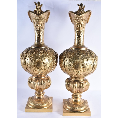 233 - A LARGE PAIR OF 19TH CENTURY FRENCH GILT BRONZE EWERS decorated in relief with classical figures and... 