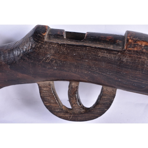 24 - AN UNUSUAL AFRICAN CARVED ZITAN WOOD SCULPTURE OF A GUN. 65 cm long.