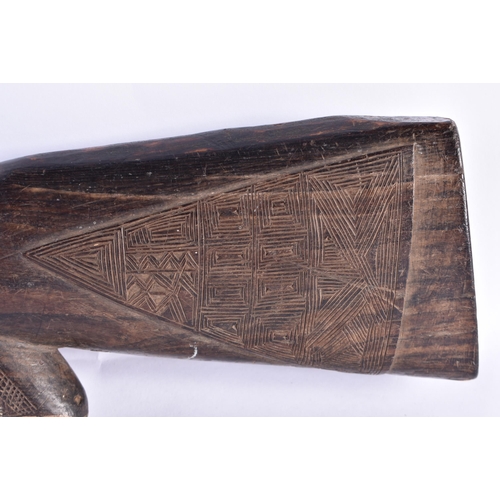 24 - AN UNUSUAL AFRICAN CARVED ZITAN WOOD SCULPTURE OF A GUN. 65 cm long.