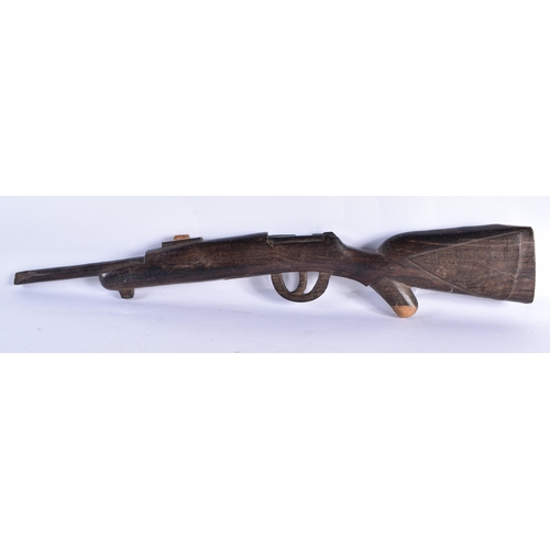 24 - AN UNUSUAL AFRICAN CARVED ZITAN WOOD SCULPTURE OF A GUN. 65 cm long.