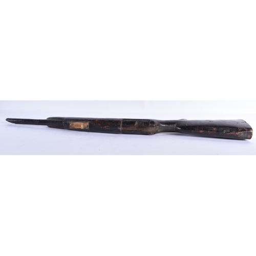 24 - AN UNUSUAL AFRICAN CARVED ZITAN WOOD SCULPTURE OF A GUN. 65 cm long.