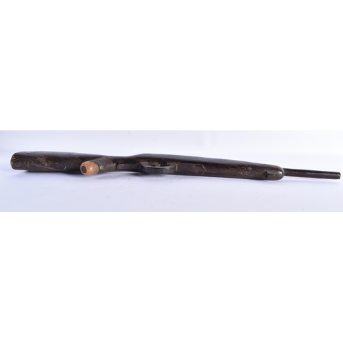 24 - AN UNUSUAL AFRICAN CARVED ZITAN WOOD SCULPTURE OF A GUN. 65 cm long.