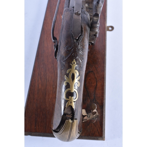 272 - AN ANTIQUE PISTOL  upon a stand. 38 cm wide.