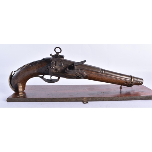 272 - AN ANTIQUE PISTOL  upon a stand. 38 cm wide.