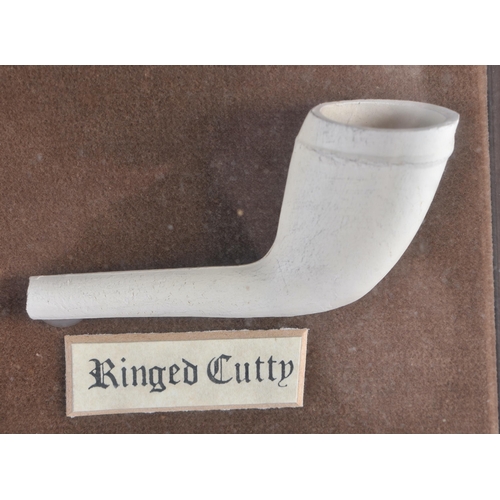 322 - A UNUSUAL ANTIQUE CLAY PIPE DISPLAY. 38 cm x 28 cm.