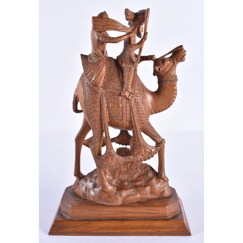 37 - A 19TH CENTURY ANGLO INDIAN CARVED WOOD FIGURE OF A CAMEL with attendants. 24 cm x 14 cm.