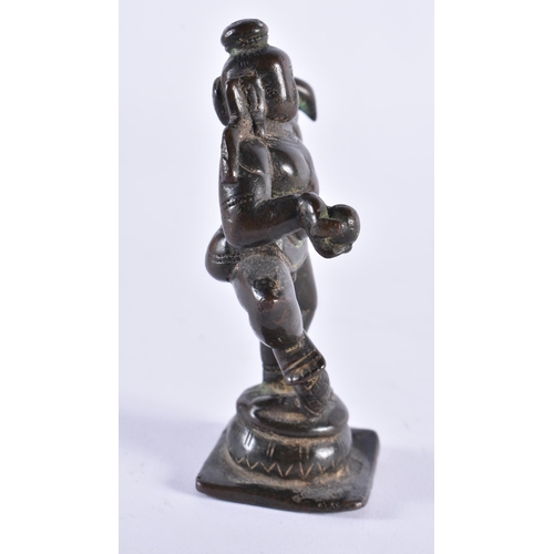 385 - AN 18TH CENTURY INDIAN BRONZE FIGURE OF A HINDU DEITY modelled with one side arm raised. 11 cm high.