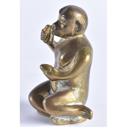 389 - A SMALL 19TH CENTURY BRONZE FIGURE OF A SEATED MONKEY possibly modelled taking snuff. 6 cm high.