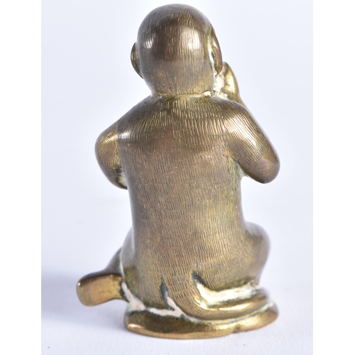 389 - A SMALL 19TH CENTURY BRONZE FIGURE OF A SEATED MONKEY possibly modelled taking snuff. 6 cm high.