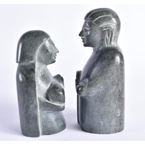 402 - TWO INUIT CARVED STONE FIGURES possibly representing nativity. Largest 15 cm high. (2)