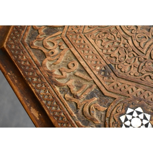 415 - A 19TH CENTURY MIDDLE EASTERN ISLAMIC CARVED WOOD TABLE decorated with calligraphy. 79cm x 75cm x 47... 