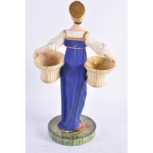 419 - A LATE 19TH CENTURY RUSSIAN PORCELAIN FIGURE modelled as a female holding two baskets. 23 cm high.