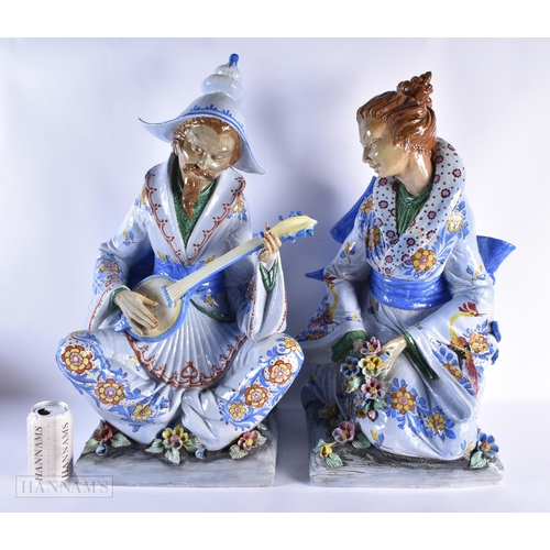 460 - A VERY LARGE PAIR OF ITALIAN CERAMIC POTTERY FIGURES OF A MALE AND FEMALE modelled in robes embellis... 