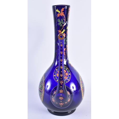 60 - AN EARLY 20TH CENTURY CONTINENAL IZNIK STYLE ENAMELLED BLUE GLASS EWER decorated with foliage. 37 cm... 