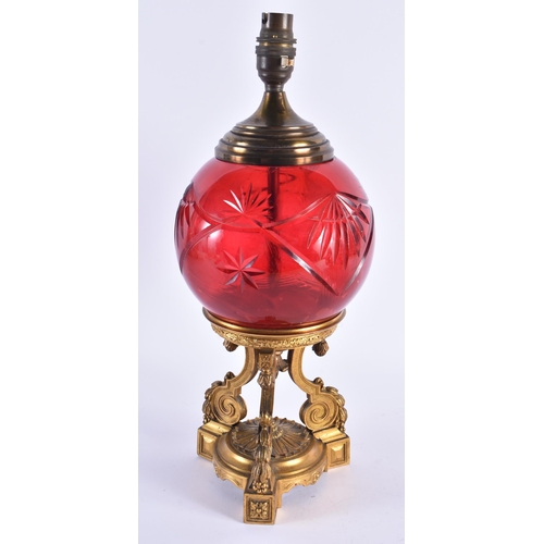 61 - A LATE 19TH CENTURY EUROPEAN GILT BRONZE AND RUBY GLASS LAMP the central body supported on a fine qu... 