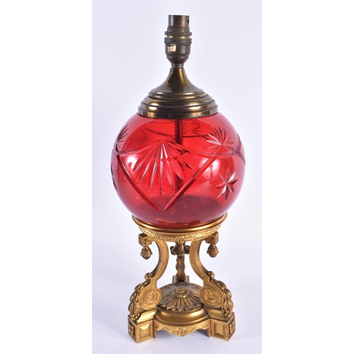 61 - A LATE 19TH CENTURY EUROPEAN GILT BRONZE AND RUBY GLASS LAMP the central body supported on a fine qu... 