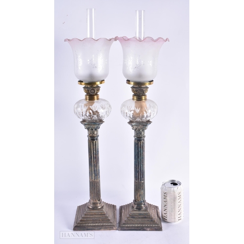 669 - A LARGE PAIR OF VICTORIAN SILVER PLATED OIL LAMPS. 57 cm high.